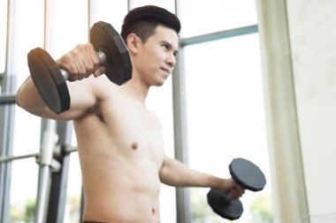 Asya kaslı adam spor salonunda halter kaldırma. kopya alanı.