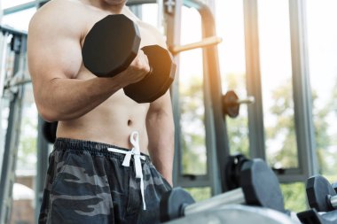 Asya kaslı adam spor salonunda halter kaldırma. kopya alanı.