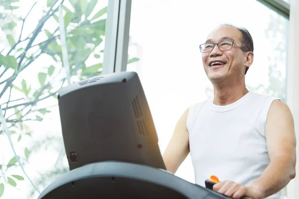 Azjatycka starszy mężczyzna, ćwiczenia na bieżni maszyny z c z bliska — Zdjęcie stockowe