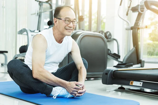 Azjatycka starszy człowiek Stretching przed treningu na siłowni. Skopiuj spac — Zdjęcie stockowe