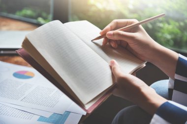 Kadın eller üstünde bir defter yazma.