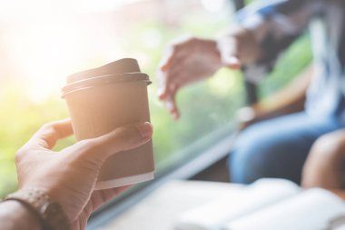 Bir fincan kahve bir kadına teslim adam.