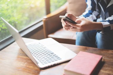 Deri koltukta oturan ve cep telefonu kullanarak kadın. Dizüstü bilgisayar, Not