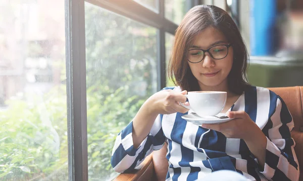 Relaxado mulher asiática segurando uma xícara de café quente. Olho de felicidade — Fotografia de Stock