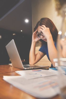 Asya gözlük kadın ile laptop ve grafik financi, vurguladı