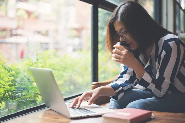 Relaxado Asiático Mulher bebendo café enquanto trabalhava com laptop em — Fotografia de Stock