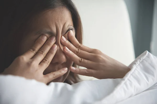 Mujer asiática frotando los ojos con las manos en la cama. Copiar espacio . — Foto de Stock