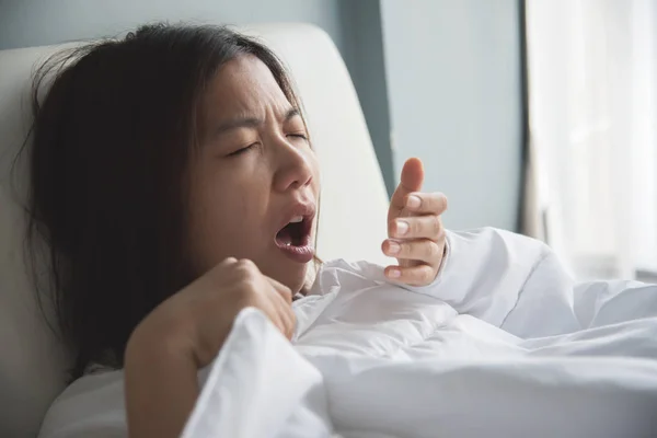 Mulher asiática constipada. A rapariga está a tossir na cama. Doença , — Fotografia de Stock