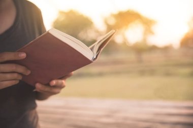 Kız kırsal arka plan üzerine bir kitap okuma. 