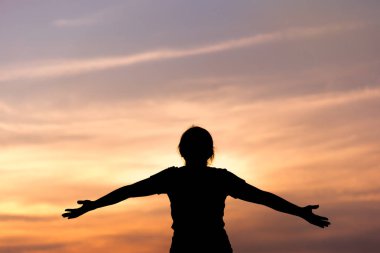 Siluet genç kadında rahatlatıcı günbatımı gökyüzü açık. 