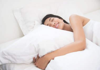 Asyalı güzel kadın yatağında uyuyan. 