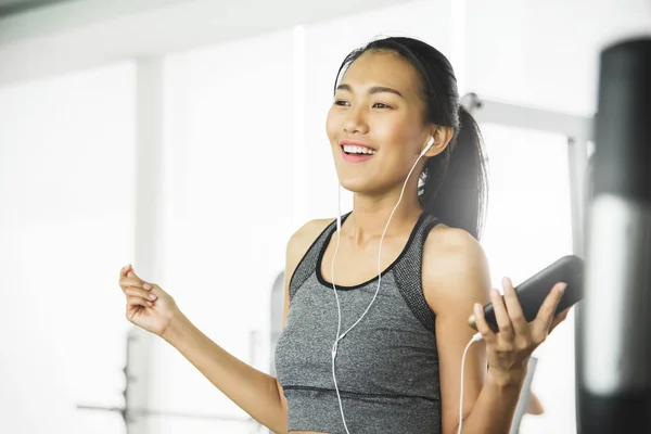 Relajada mujer asiática en ropa deportiva escuchando la música —  Fotos de Stock