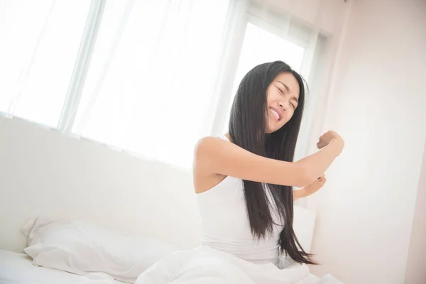 Hermosa mujer asiática despertando en su cama por la mañana . — Foto de Stock