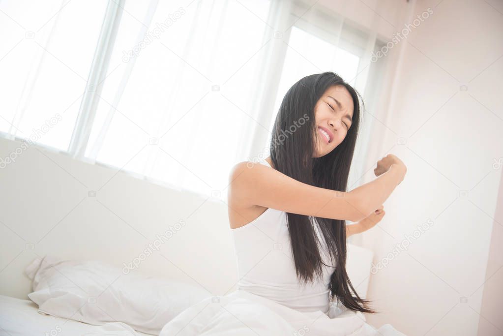 Beautiful Asian woman waking up on her bed in the morning. 