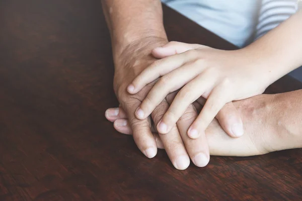 Primer plano de Senior y niño se unen de la mano. Trabajo en equipo del consejo familiar —  Fotos de Stock