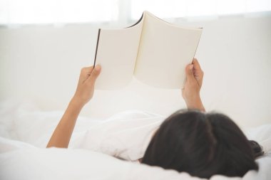 Gönüllülük a kitap onun yatağında rahat Asyalı kız.