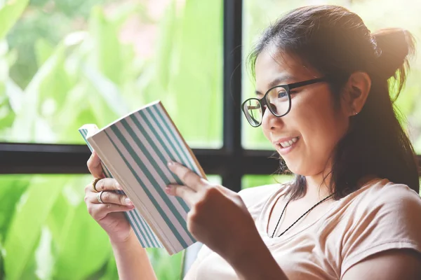 Focus on book. Relaxed Asian Woman  reading a book. — Stock Photo, Image