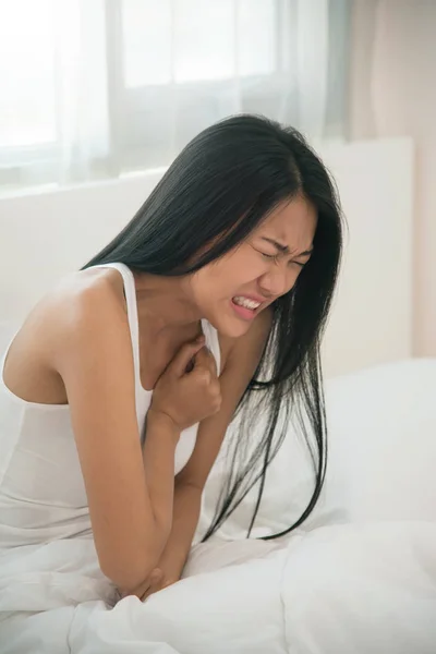 Mulher asiática tendo ataque cardíaco em sua cama. espaço de cópia . — Fotografia de Stock