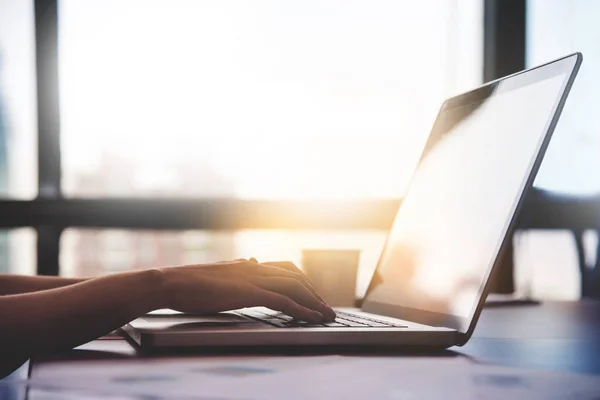 Fechar as mãos da mulher usando laptop para o seu trabalho na luz solar backg — Fotografia de Stock