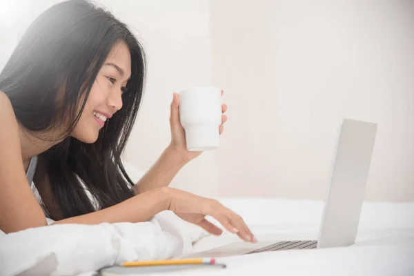 Bonheur fille asiatique souriant et tenant tasse de café avec lapt — Photo