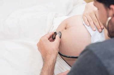 Koca stetoskop kullanarak.