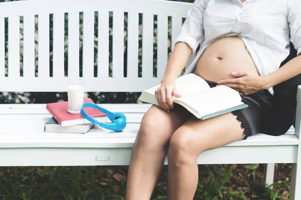 Ασιατικές έγκυος γυναίκα διαβάζοντας ένα βιβλίο. — Φωτογραφία Αρχείου