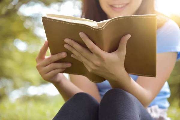 Азиатка в синей рубашке читает книгу . — стоковое фото