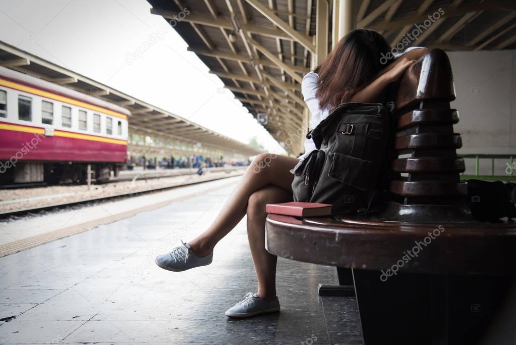 Female backpacker is waiting a train.