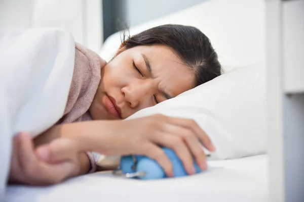 Sonolento mulher asiática segurando relógio de alarme . — Fotografia de Stock