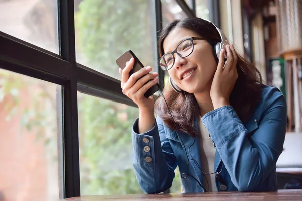 Азиатка слушает музыку в наушниках . — стоковое фото