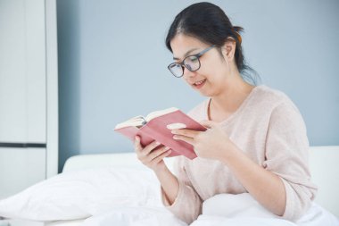 Mutlu güzel Asyalı kadın kitap okumak.