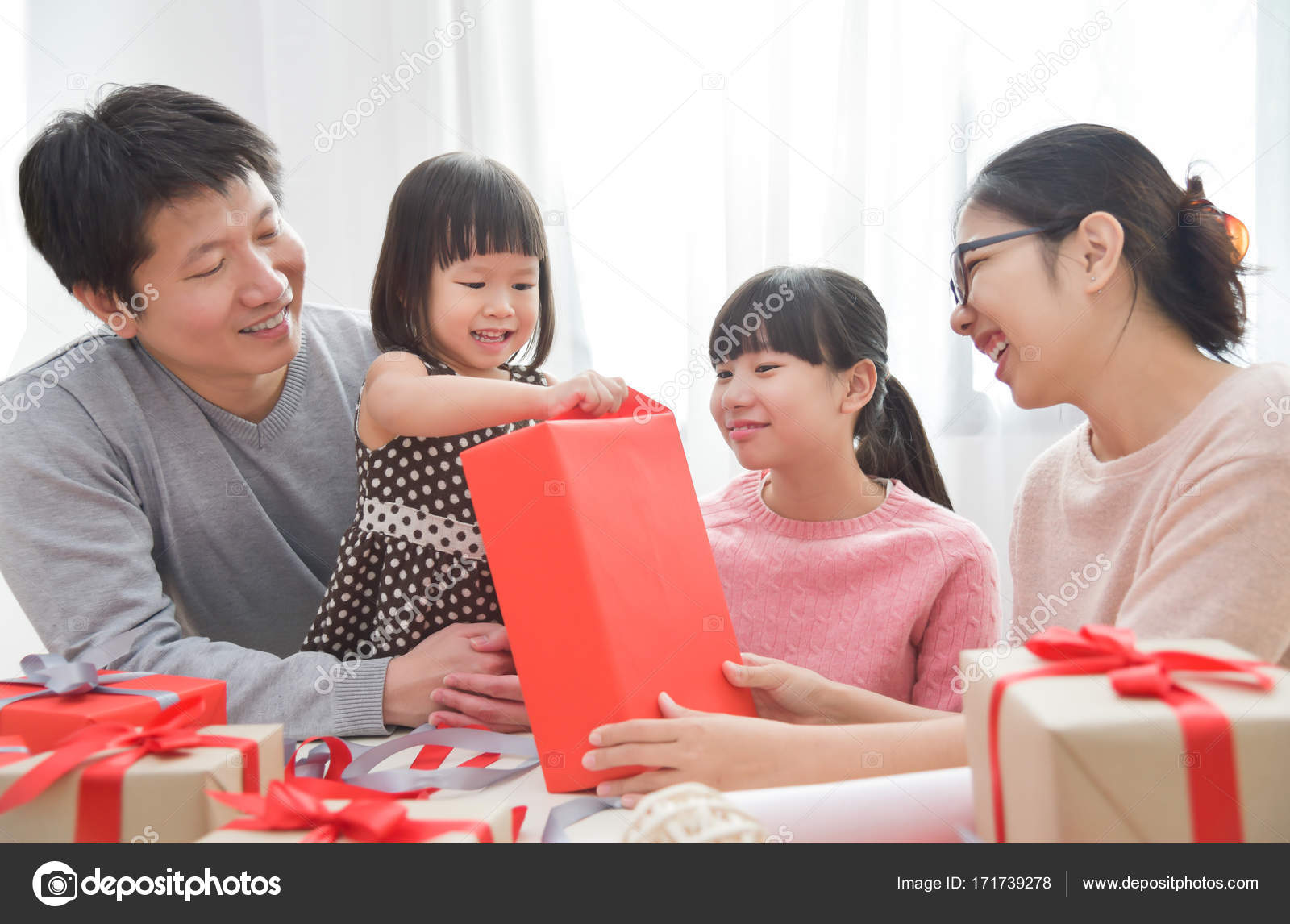 https://st3.depositphotos.com/3802127/17173/i/1600/depositphotos_171739278-stock-photo-happy-asian-family-unwrapping-a.jpg