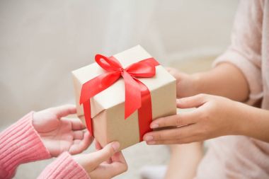 Asyalı kadın kahverengi hediye kutusu veren eller.
