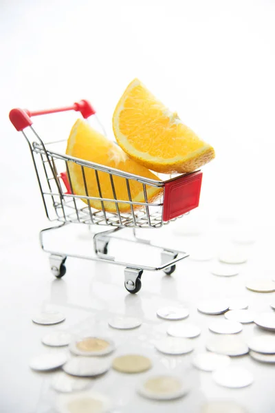 Orangenscheiben im Warenkorb mit Münzen. — Stockfoto