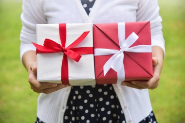 Asyalı kadın hediye kutuları tutarak.