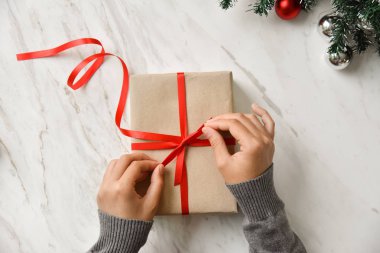 Kahverengi bir hediye kutusu kaydırma eller.