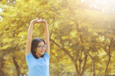 Asyalı kadın kollarını yeşil doğal arka plan üzerinde uzanan.