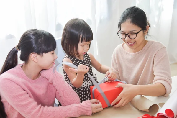 Família asiática feliz desembrulhando uma caixa de presente . — Fotografia de Stock
