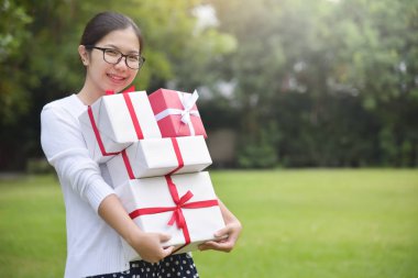 Asyalı kadın holding yığını hediye kutuları