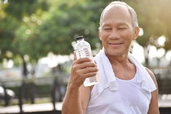 Azjatycka starszy mężczyzna gospodarstwa butelka wody. — Zdjęcie stockowe