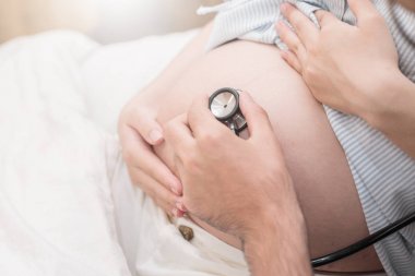 Koca el stetoskop kullanarak.