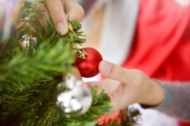 Asyalı kadın dekorasyon Noel ağacı eller.