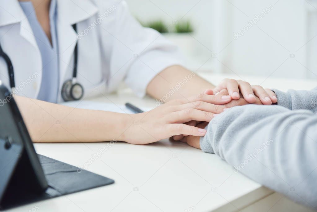 Female doctor reassuring senior male patient.