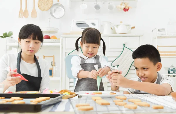 Crianças decorando biscoitos . — Fotografia de Stock