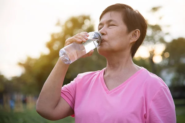 Asian senior Female drinking water. — Stock Photo, Image