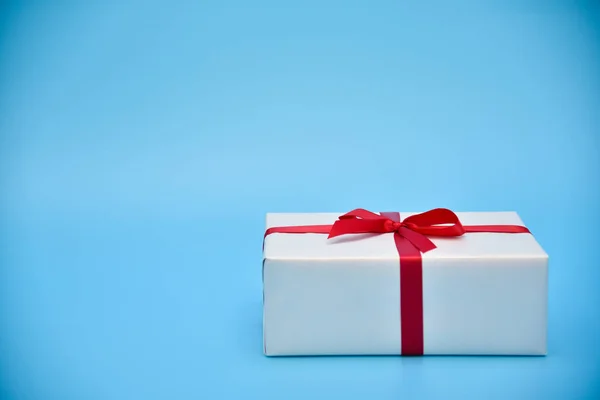 Eine weiße Geschenkbox auf blauem Hintergrund. — Stockfoto