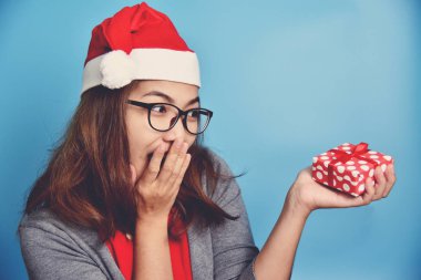 Asyalı kadın mavi zemin üzerine kırmızı hediye kutusu holding.