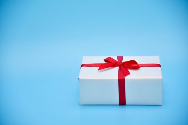Mavi zemin üzerine beyaz hediye kutusu.