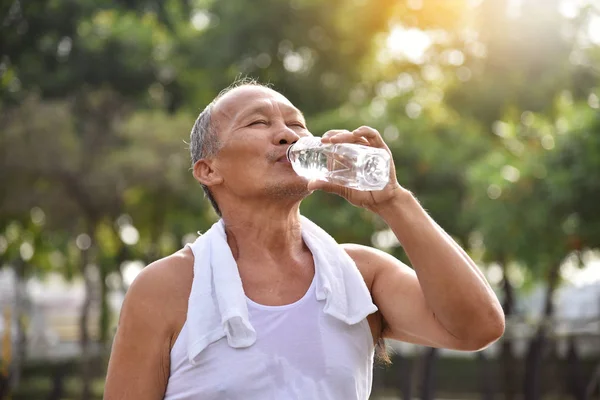 Asian senior male drinking water.