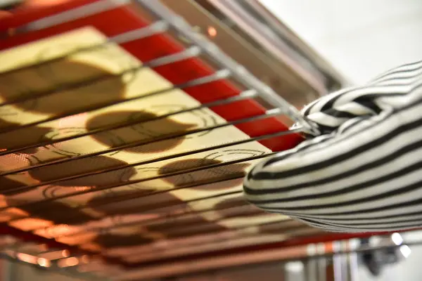 Mão com luvas tirando biscoitos do forno . — Fotografia de Stock